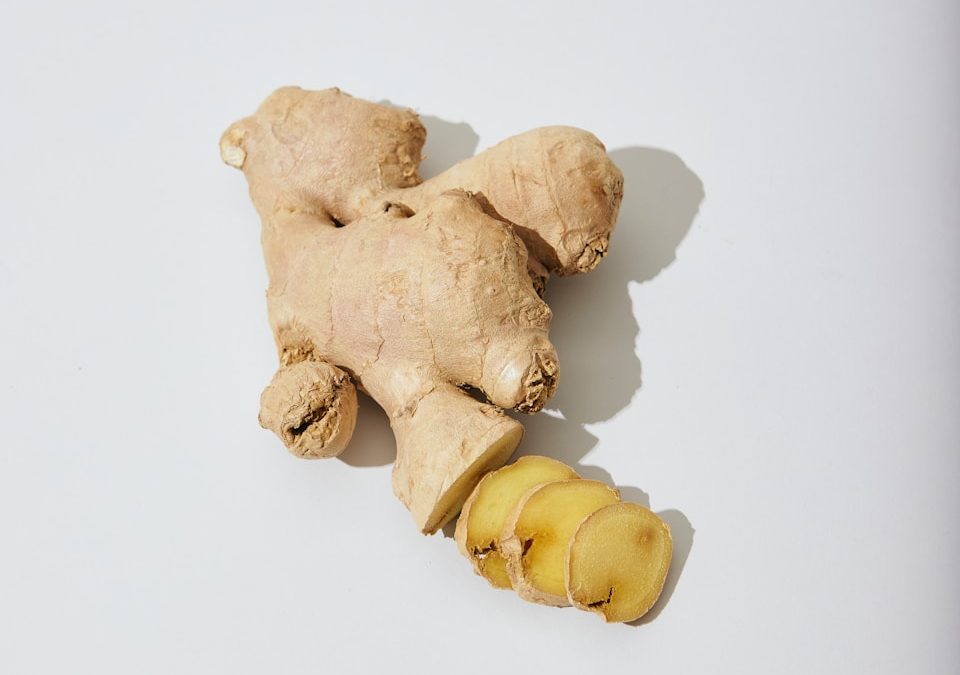 a ginger root and a piece of ginger on a white surface