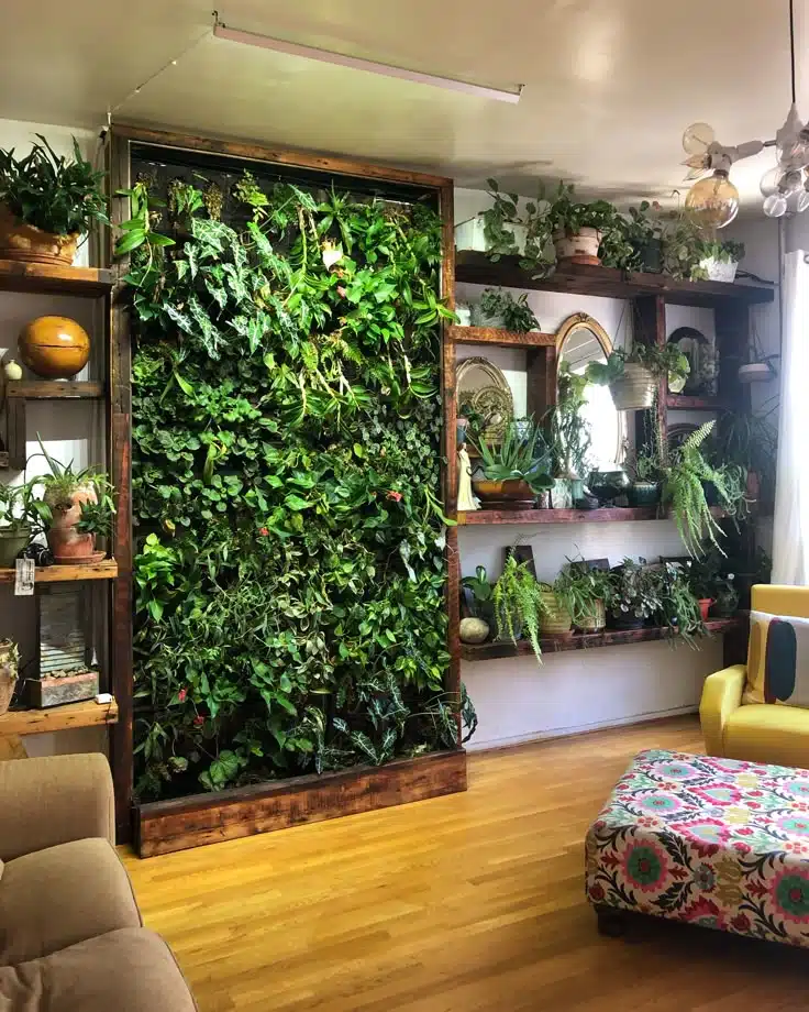 Living room with a planted wall and potted plants on shelves.